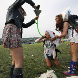 Bride-to-be Lizzie Chapman, 23, drinks cider through a funnel on arriving at Glastonbury, where she celebrates her hen night, on the second day of Glastonbury music festival at Worthy Farm in Somerset