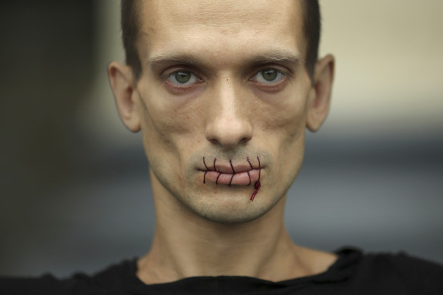 Artist Pavlensky, a supporter of jailed members of female punk band "Pussy Riot" looks on with his mouth sewed up as he protests outside the Kazan Cathedral in St. Petersburg